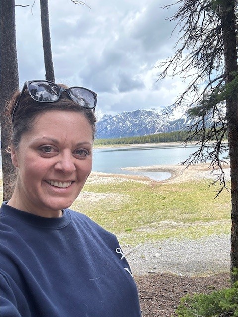 Kari Lotzien standing outdoors in nature, grounded and reflective.