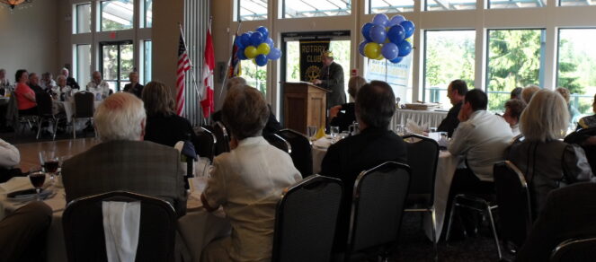 Rotary Club members and guests gathered at a community meeting, listening to a speaker and connecting in person
